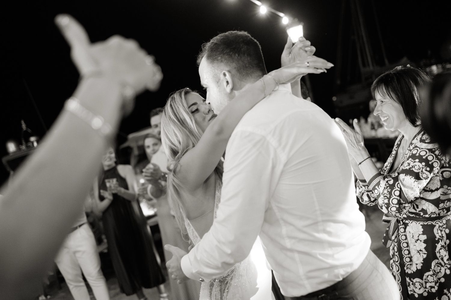 Bride and groom share a passionate kiss on the dance floor at their wedding reception.
