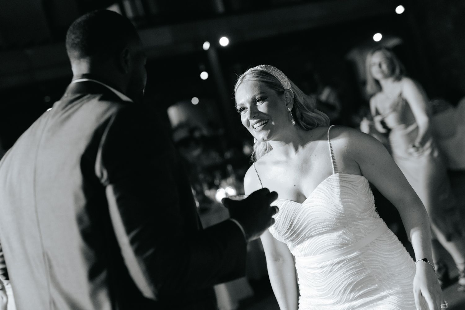 Bride in white strapless gown sharing first dance with groom at elegant wedding reception.