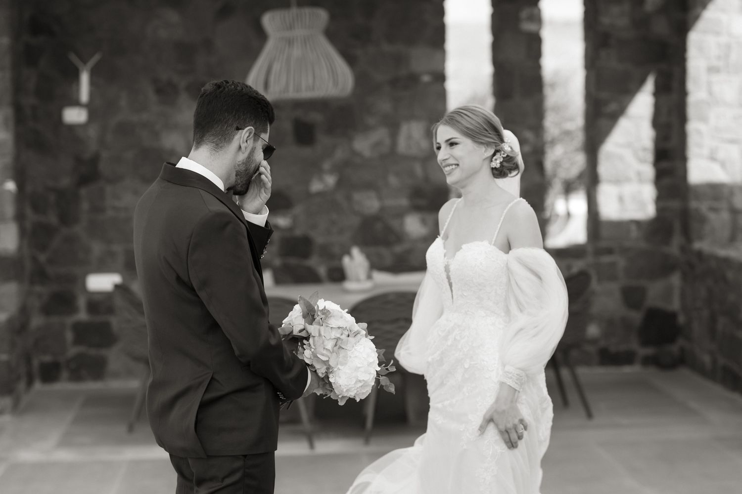 Black and white photo of bride and groom sharing a tender first look moment at their wedding.