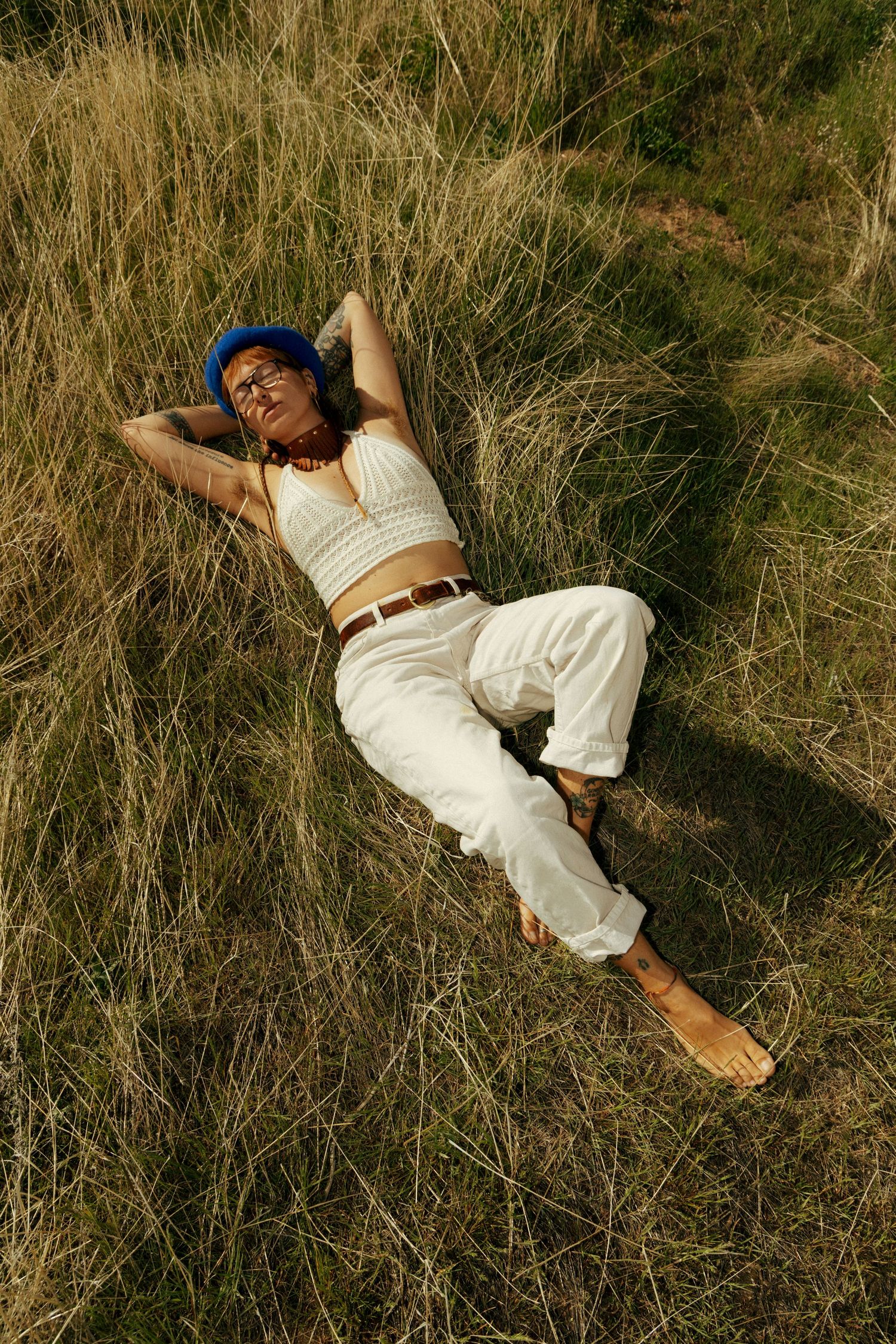Creative outdoor portrait of a woman lying in tall grass in Salt Lake City, Utah.