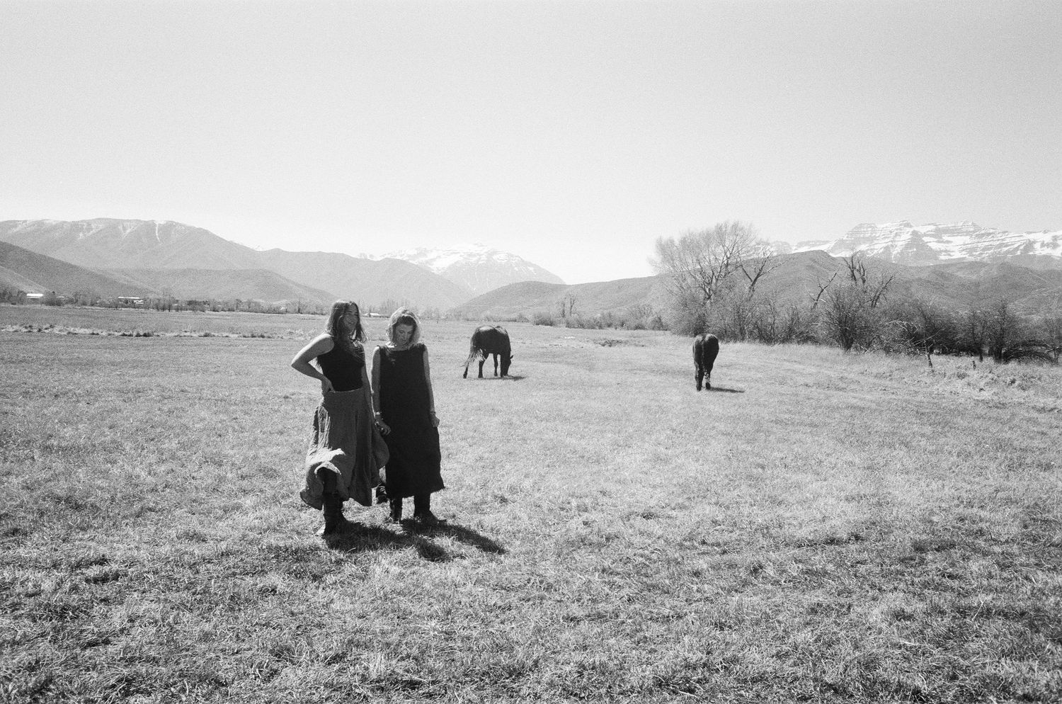 Black and white 35mm film photograph of women and horses in the Utah countryside.