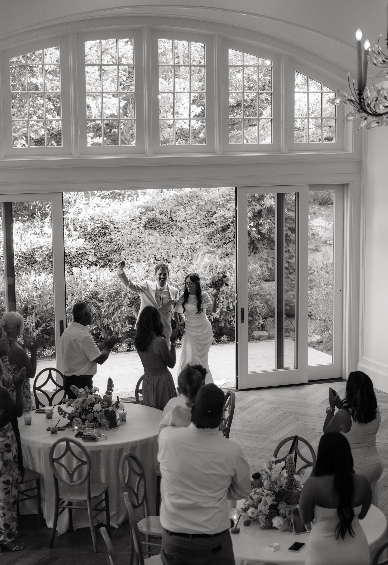 Black and white documentary photograph of guests gathered for an intimate Utah wedding reception.