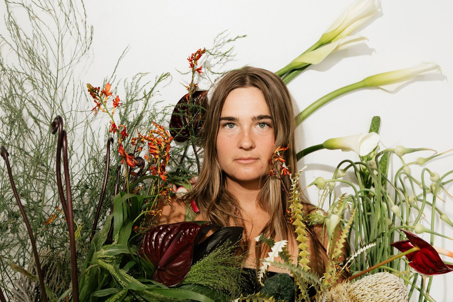 Editorial floral portrait surrounded by sculptural flower arrangements in Salt Lake City, Utah.