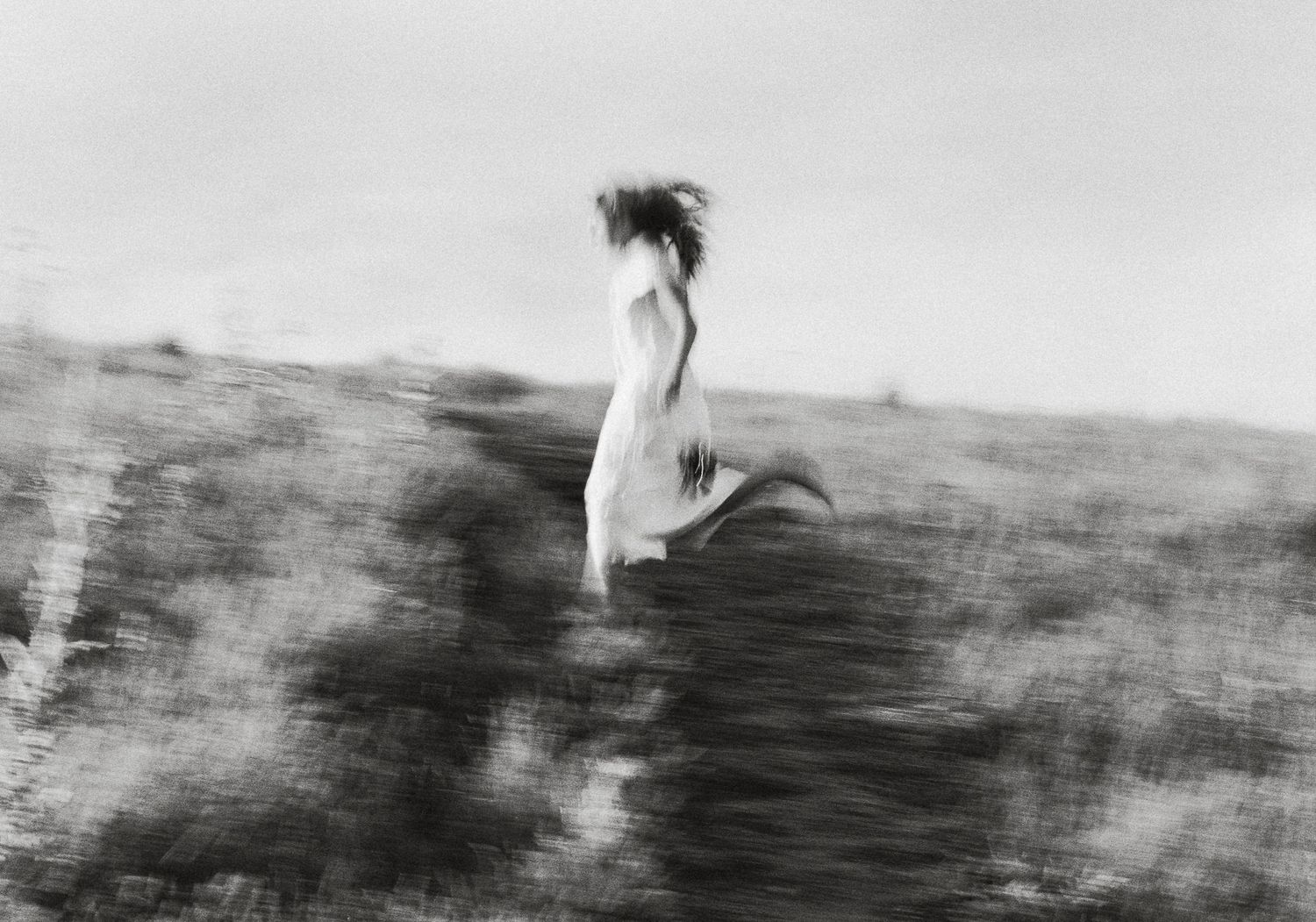 Black and white 35mm film portrait with motion blur in an open Utah landscape.
