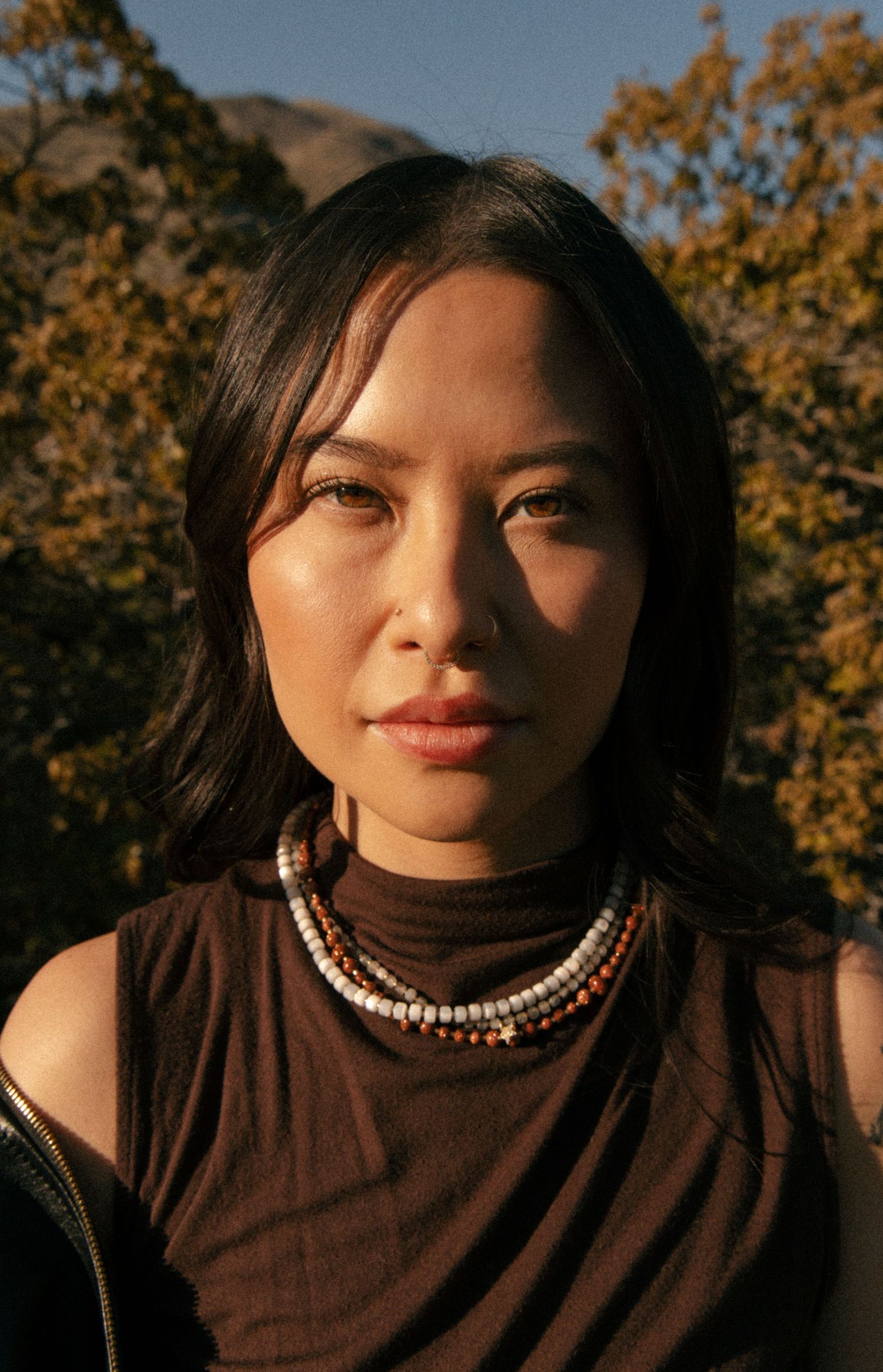 Editorial portrait featuring handmade jewelry in warm sunlight in Salt Lake City, Utah.