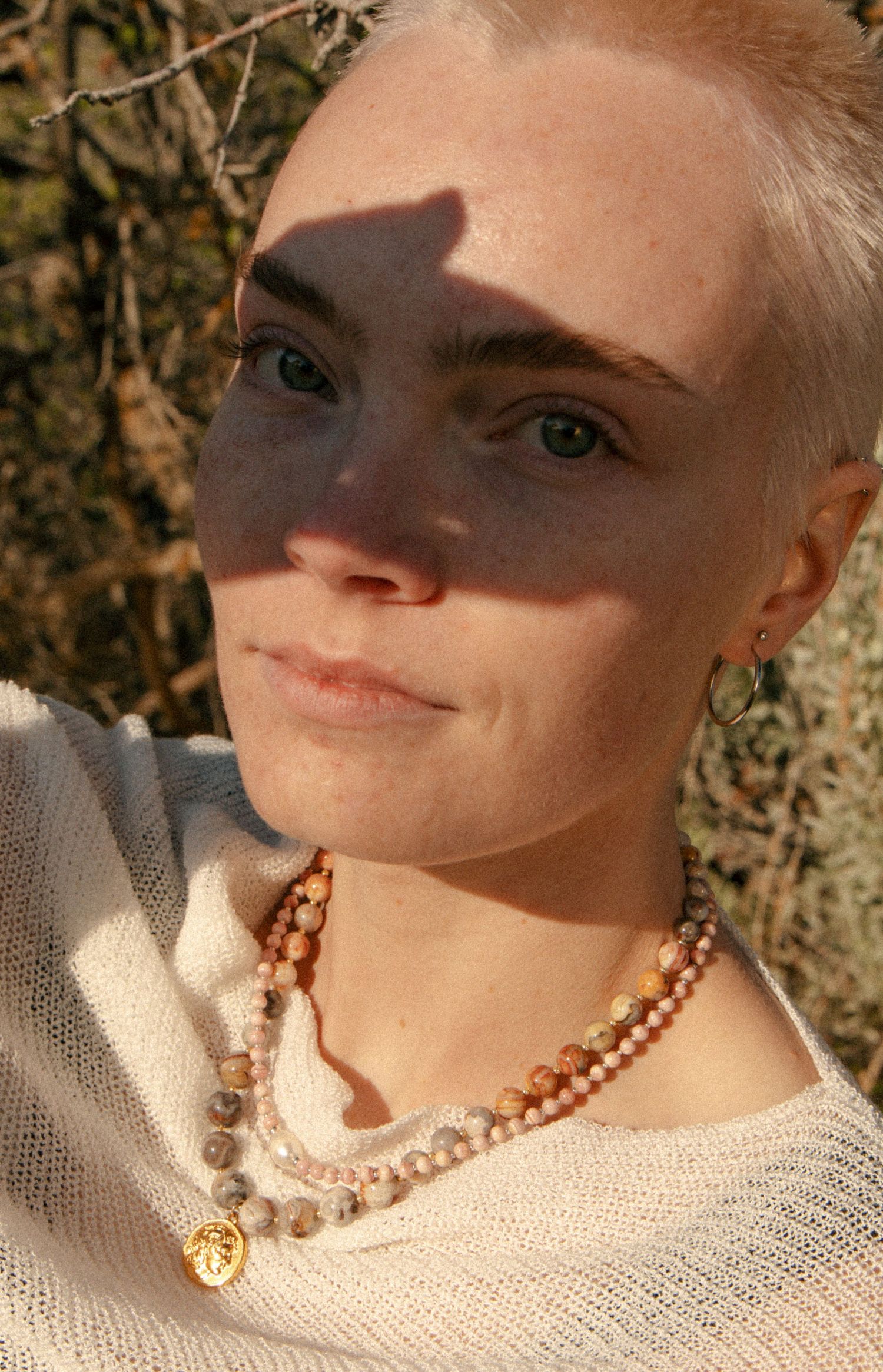 Creative portrait with layered shadows and handmade jewelry in Salt Lake City, Utah.