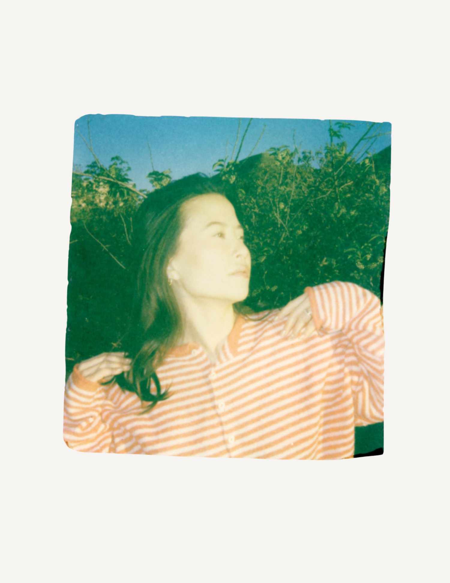 Polaroid emulsion lift of a woman outdoors with layered color and texture.