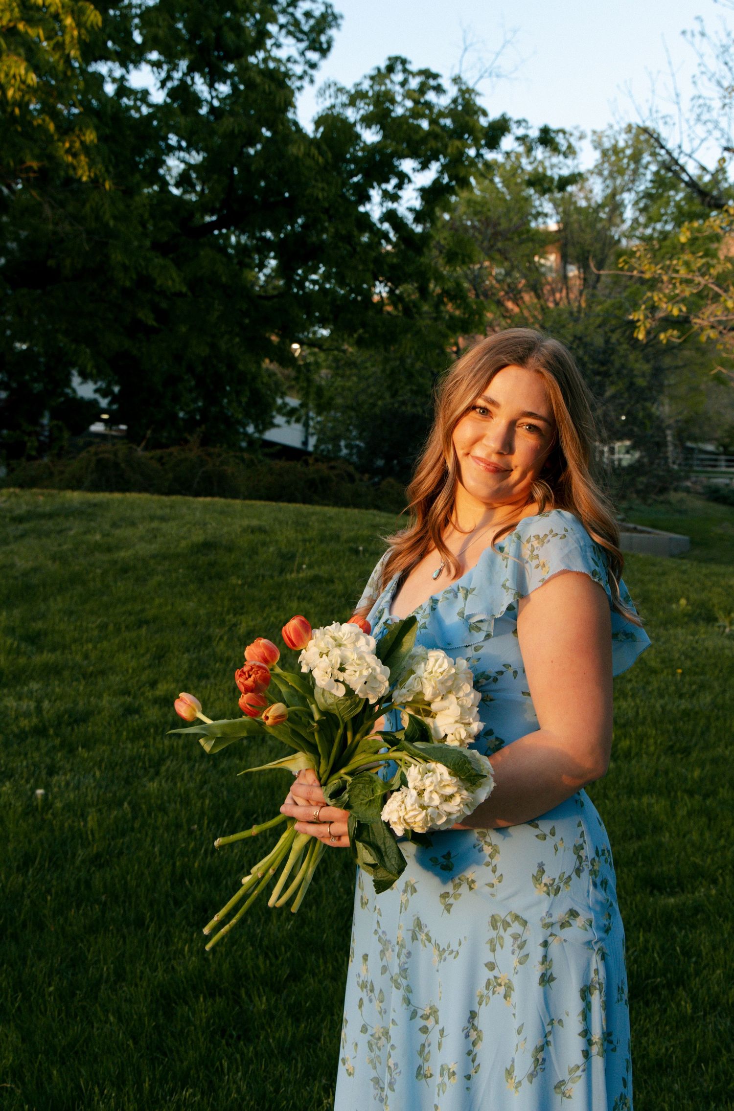 Outdoor portrait of a woman holding a floral bouquet in warm evening light in Salt Lake City, Utah.