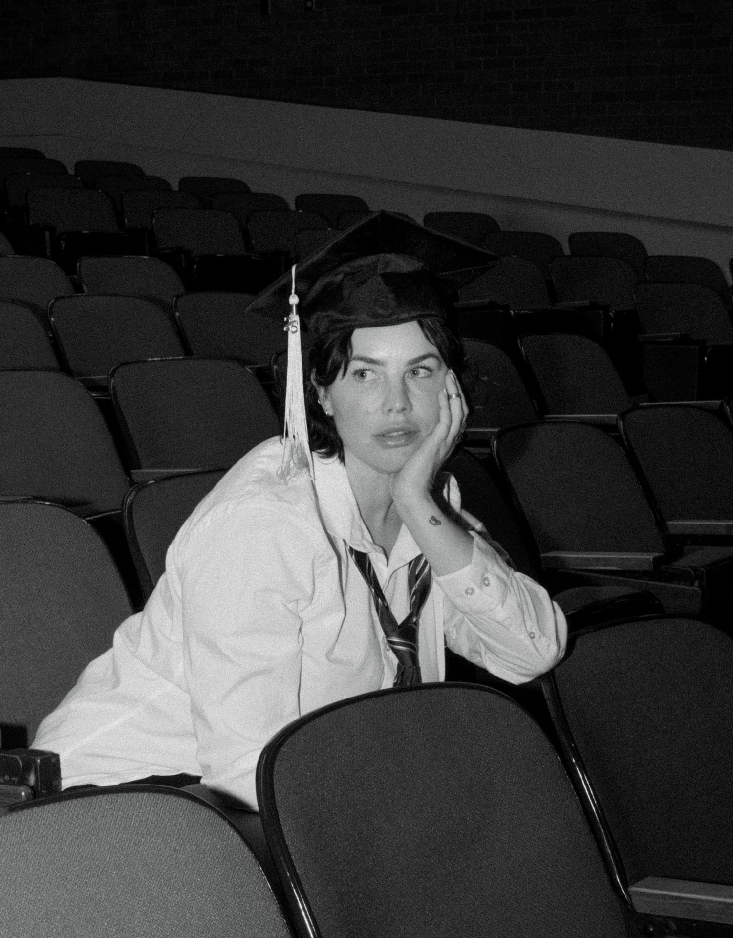 Black and white graduation portrait of a college graduate seated in a theater in Salt Lake City, Utah.