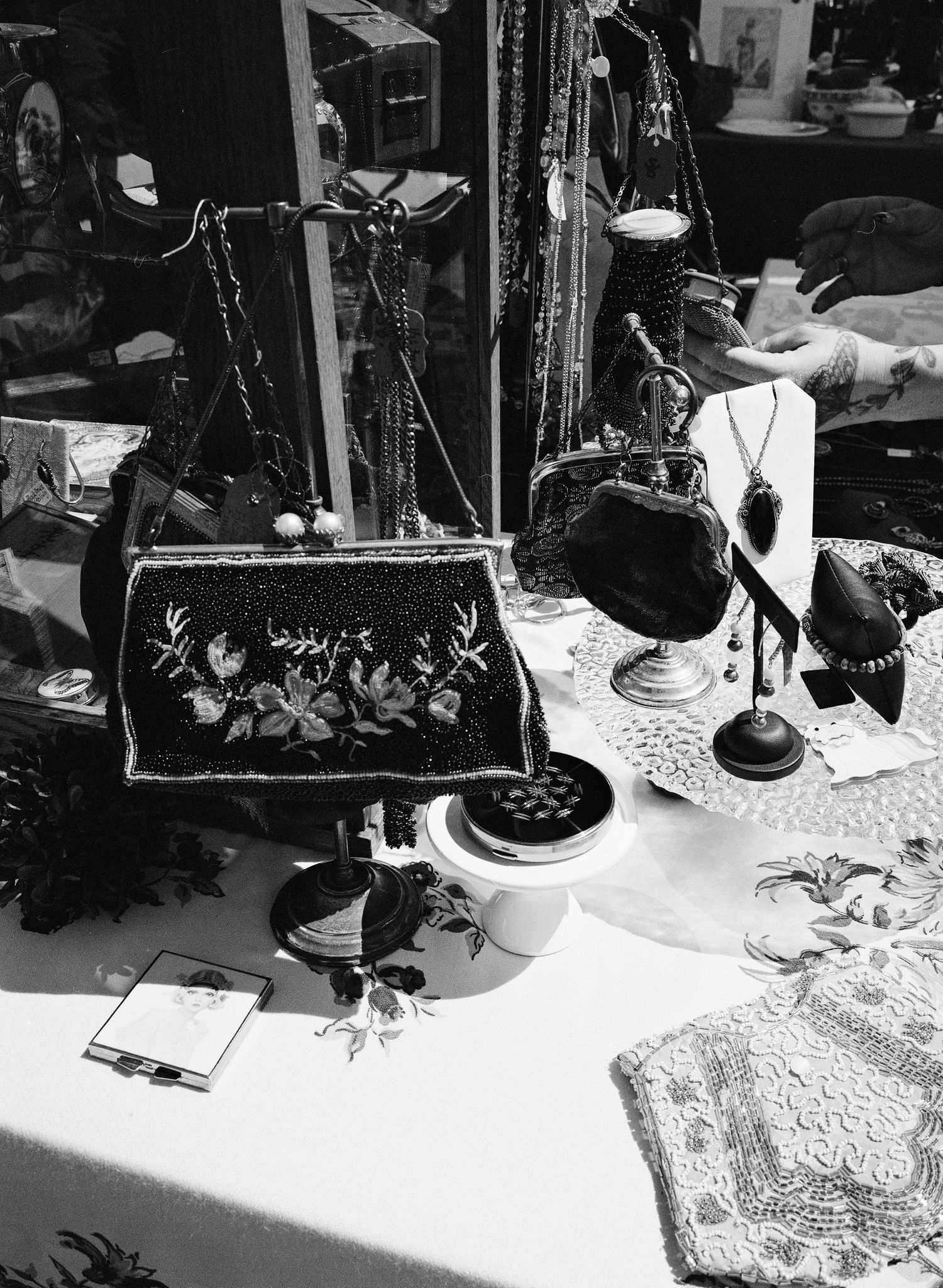 Black and white documentary photograph of handmade goods and artwork displayed at a San Francisco, California market.