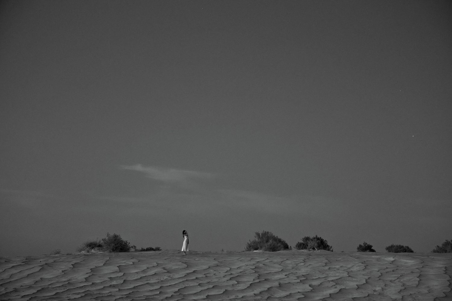 Black and white editorial portrait of a figure in a wide open Utah landscape.