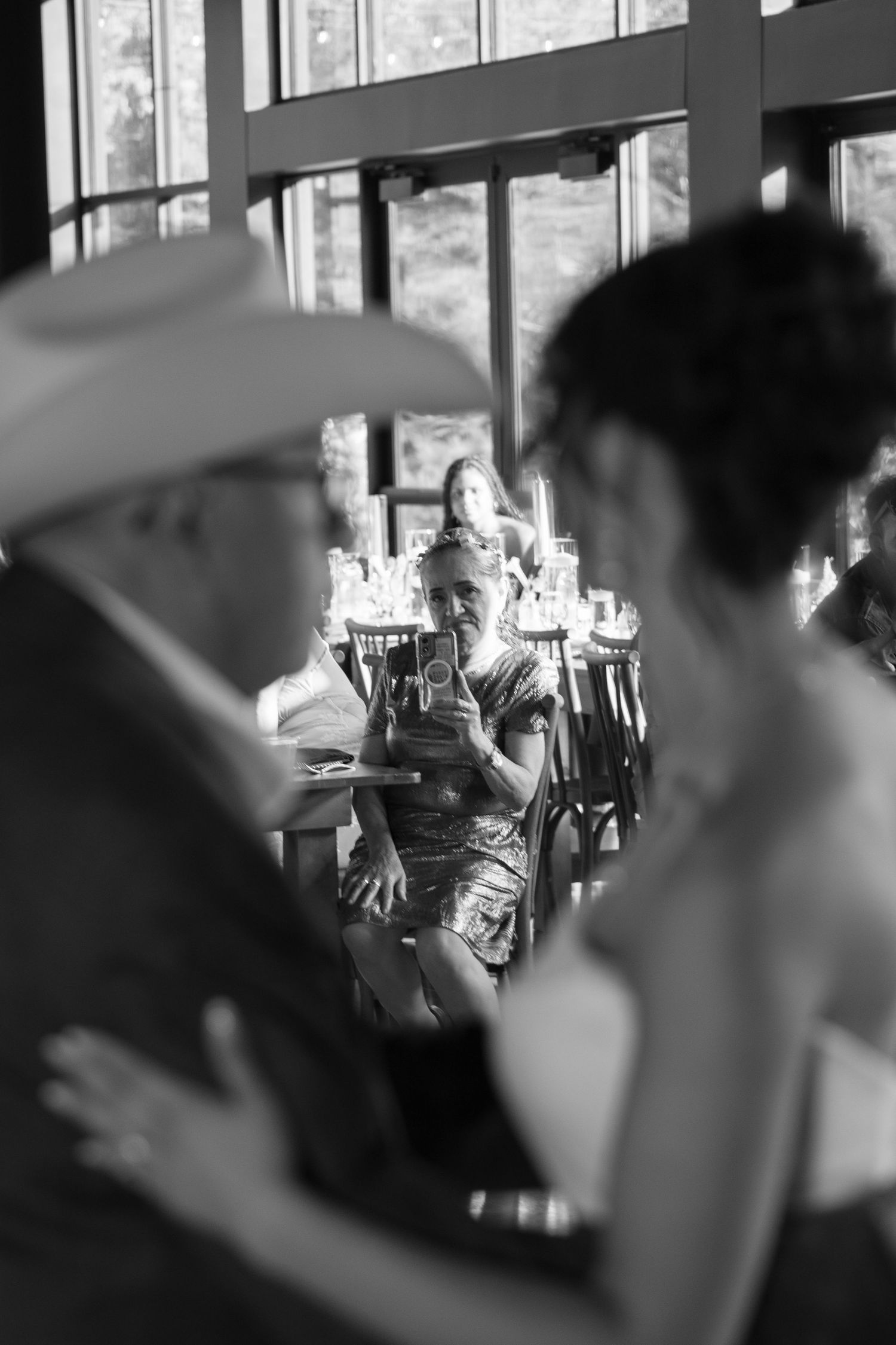 Wedding guest photographs bride and father dancing at reception in candid black and white wedding photo.