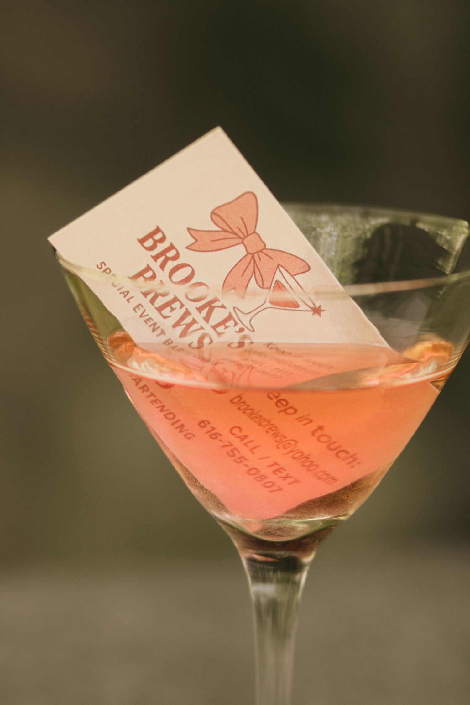 Business card for Brooke's Brews special events bartending in a pink martini cocktail glass.