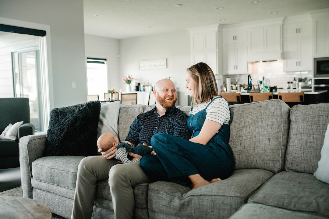 Happy couple relaxing together on gray sofa in modern home.