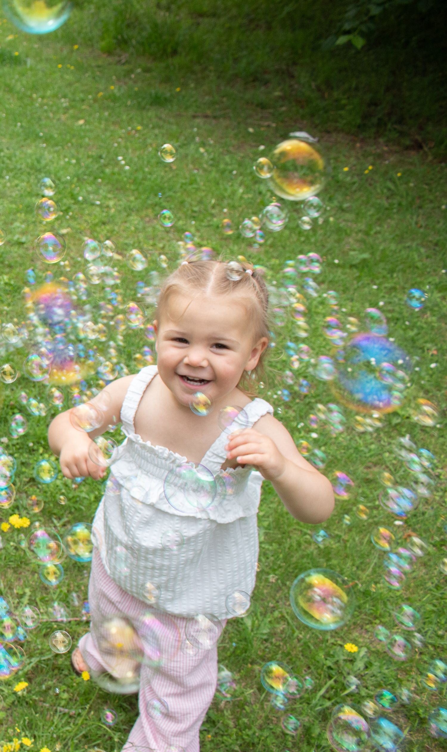 Little girl with bubbles in outdoor photography session.