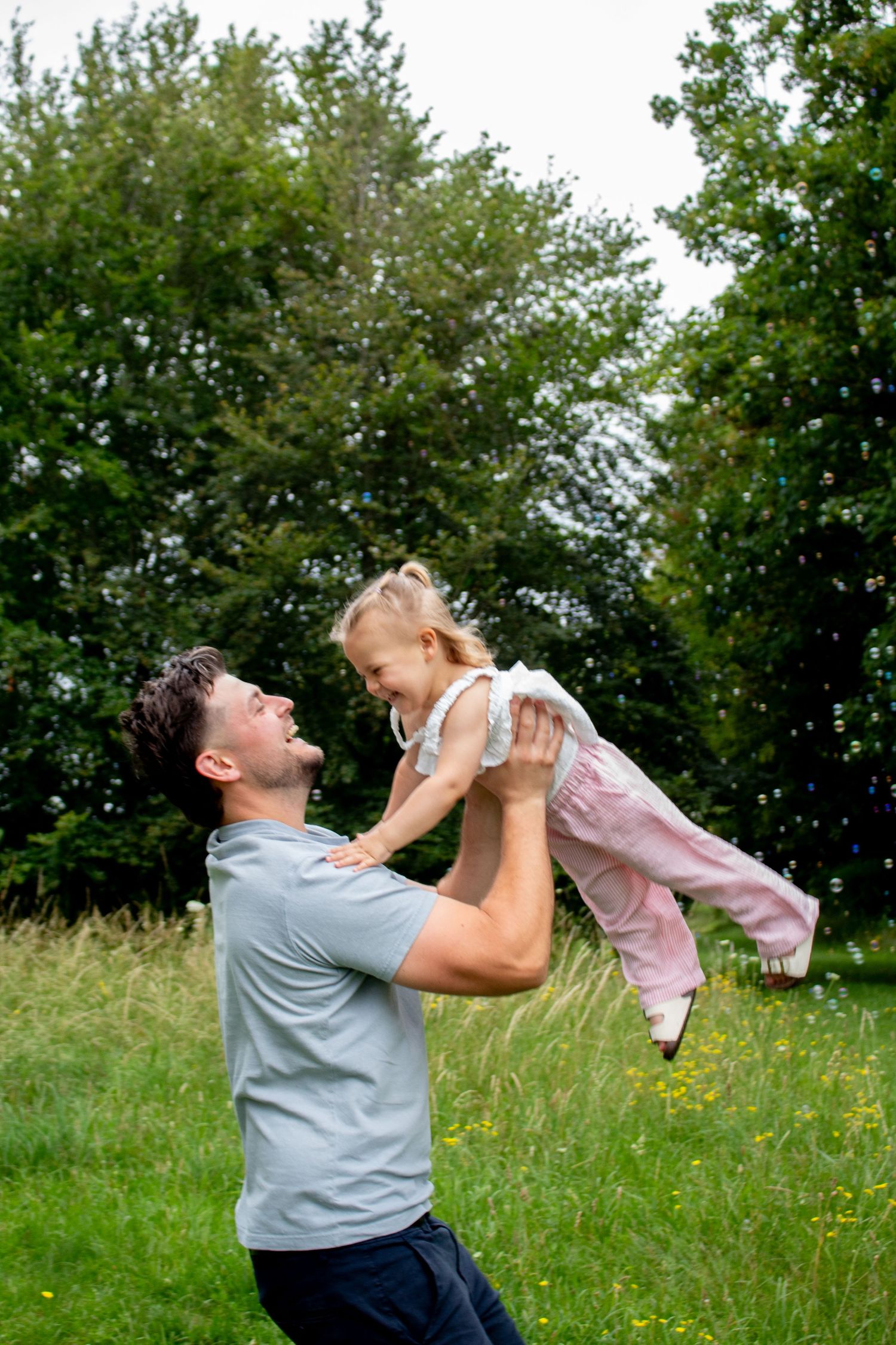 Parent lifting child in an outdoor photography session.