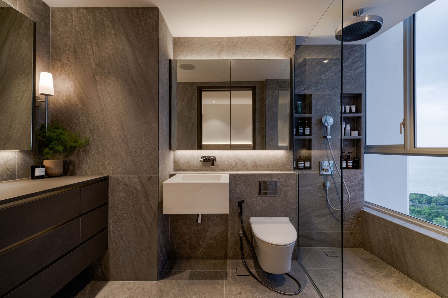 Modern bathroom interior with dark stone walls and minimalist fixtures.