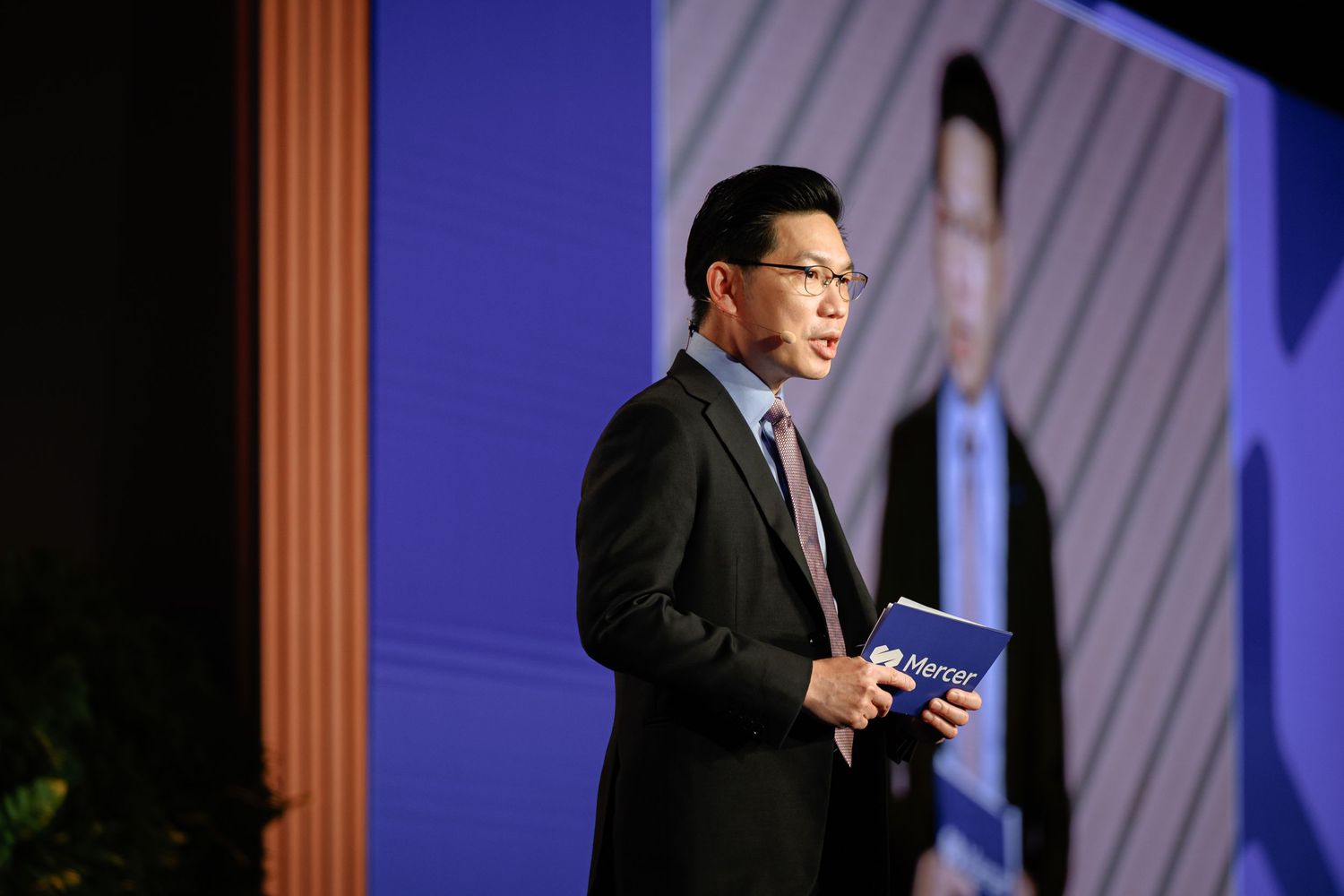 Conference stage setup with modern lighting and blue backdrop for business presentation.