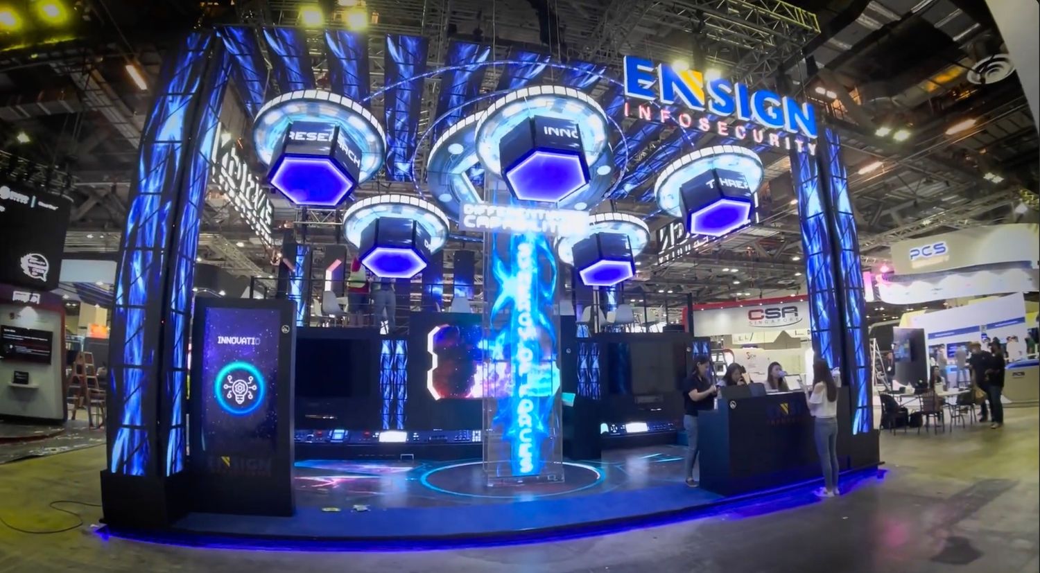 Ensign InfoSecurity trade show booth with glowing blue LED displays and futuristic design at a technology expo.
