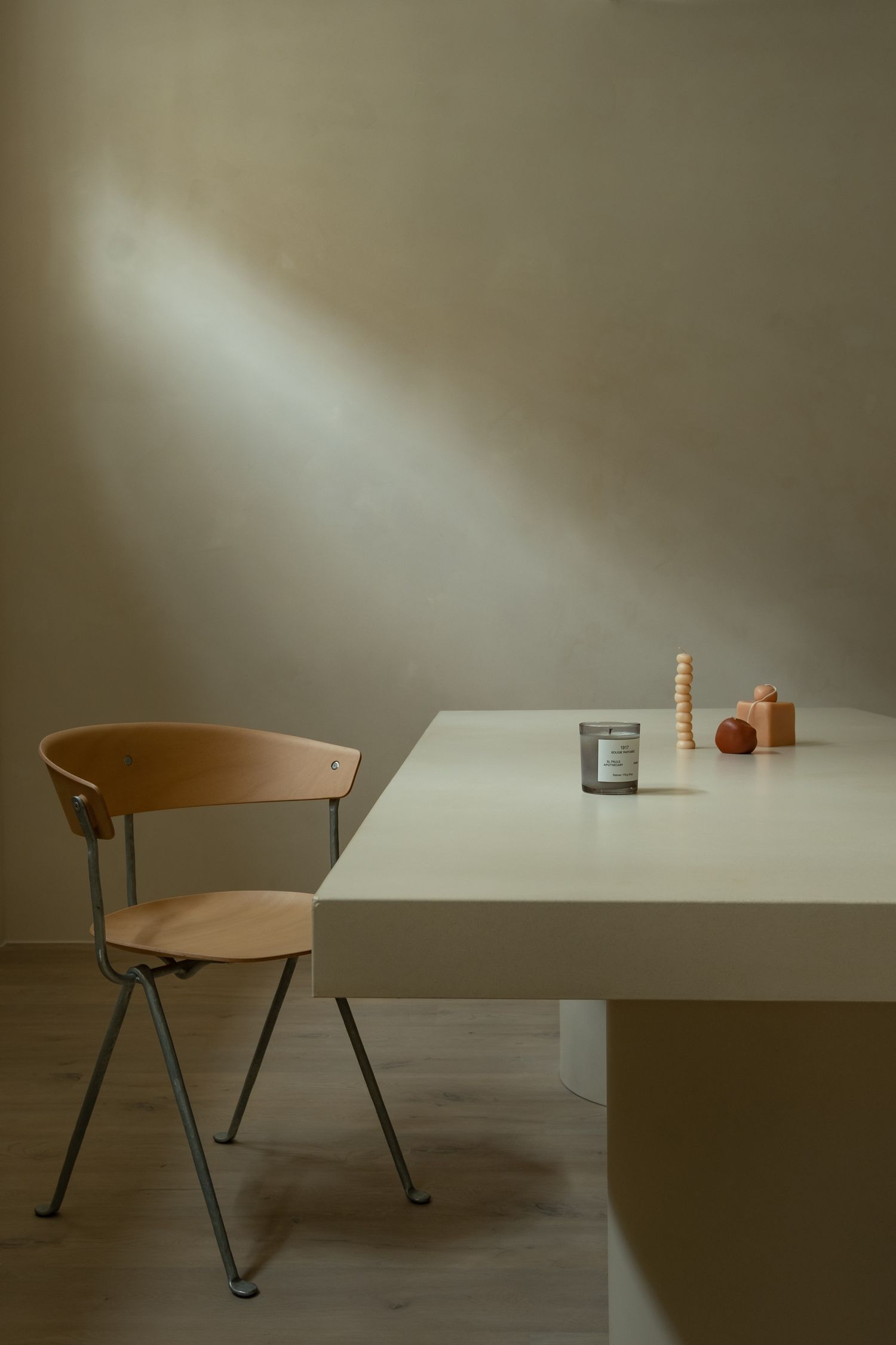 Modern chair and table arrangement in a minimalist interior with dramatic shadows.