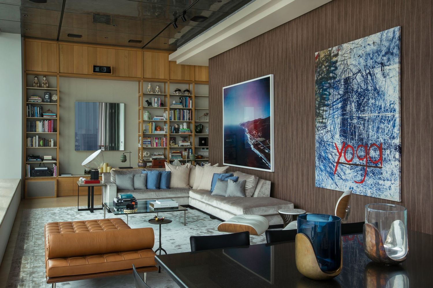 Contemporary living room with brown wood paneling and modern furniture arrangement.