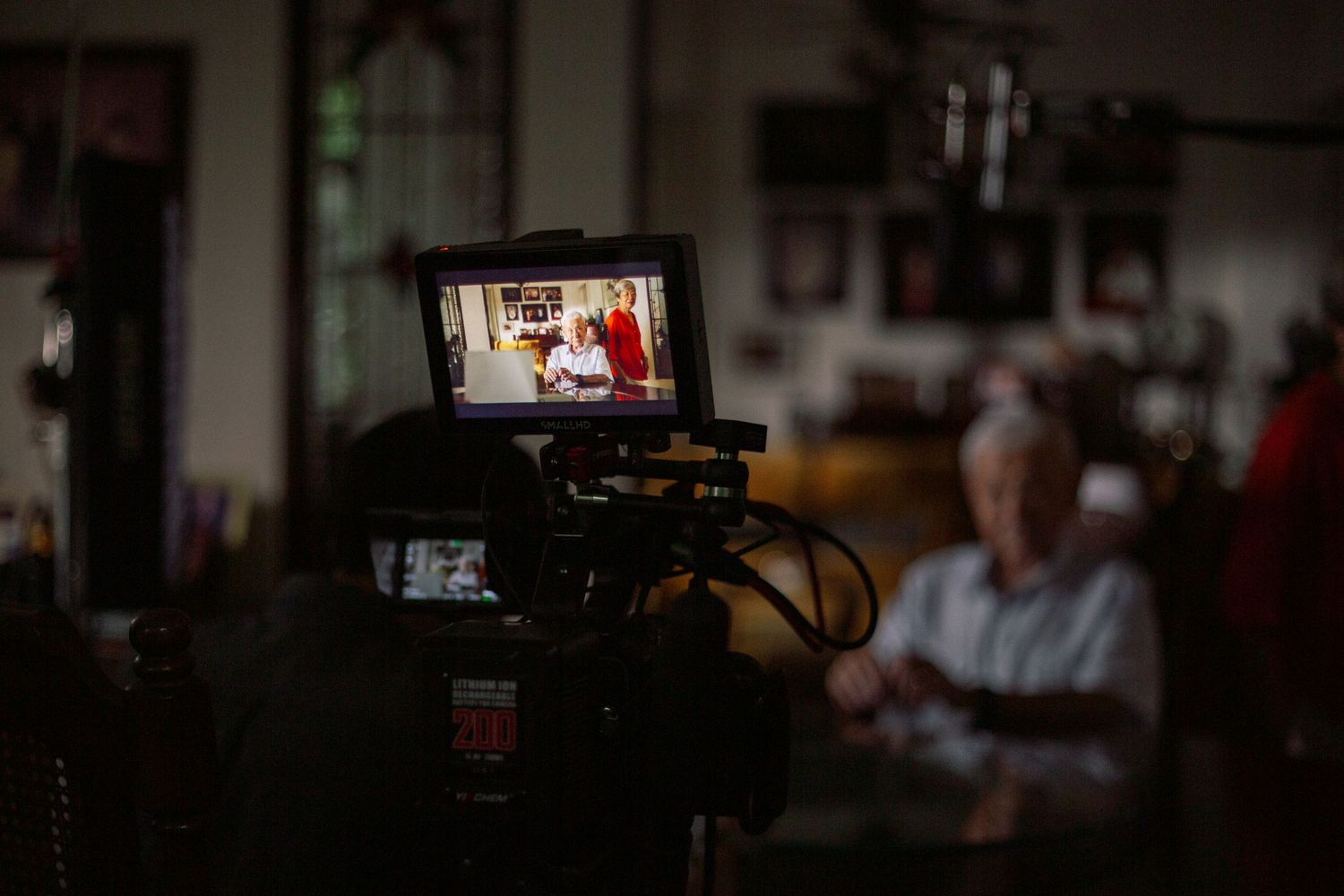 Behind-the-scenes view of film production monitors and equipment in dim lighting.
