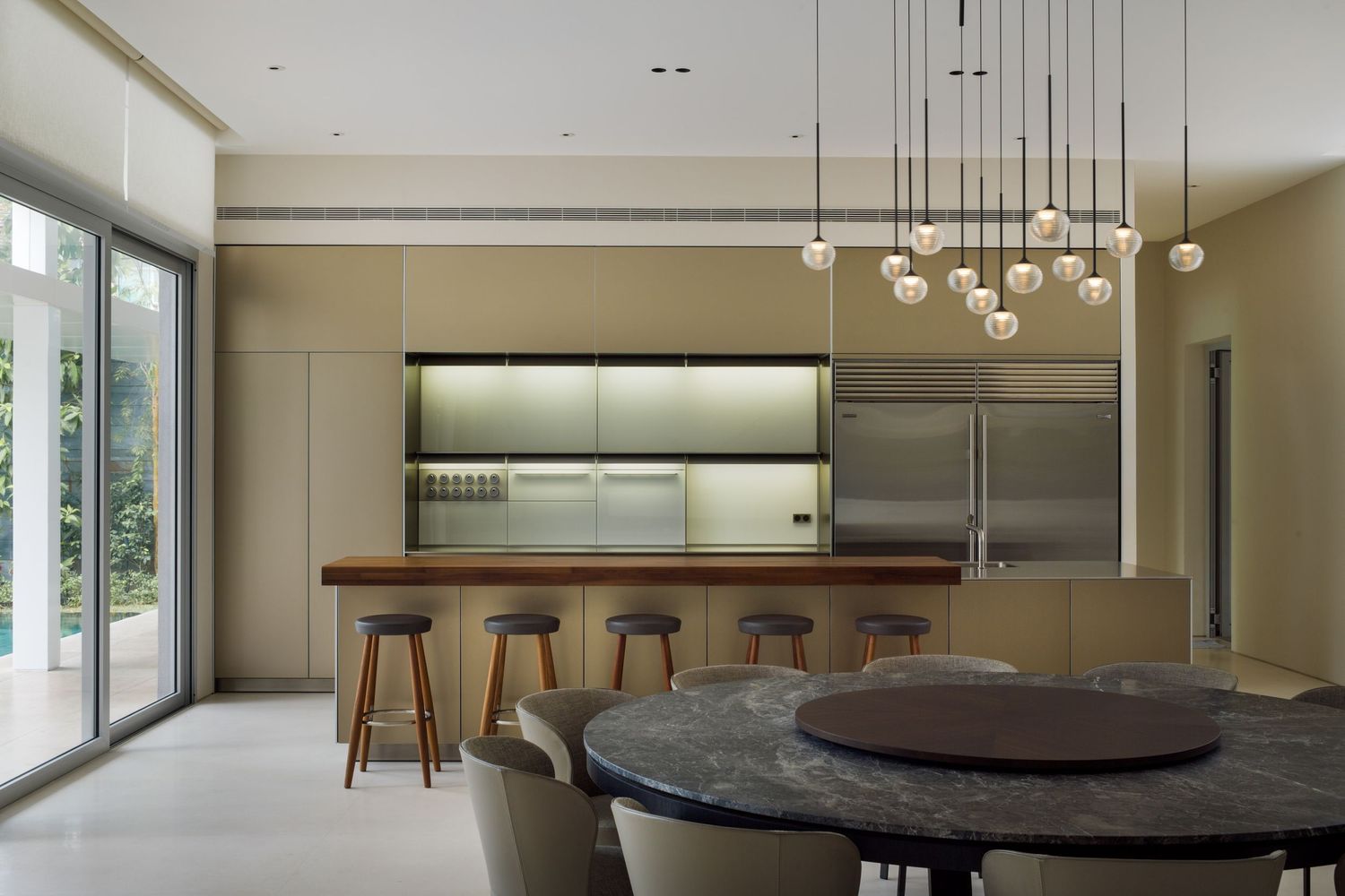 Modern minimalist dining area with pendant lights and sleek wooden furniture.