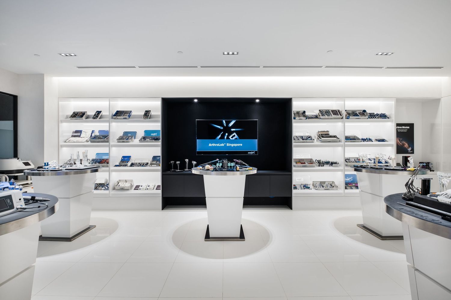 Modern minimalist retail space with clean white walls and display shelves in a sleek showroom setting.