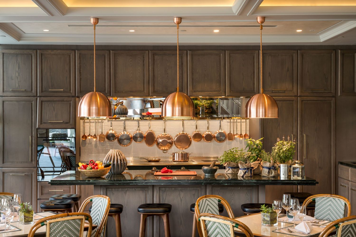 Luxurious kitchen interior with copper pendant lights and dark wood cabinetry.