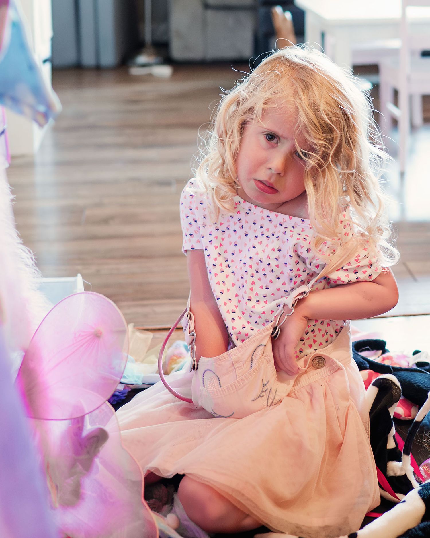 Young child preparing to play dress-up during a relaxed family photo session at home.