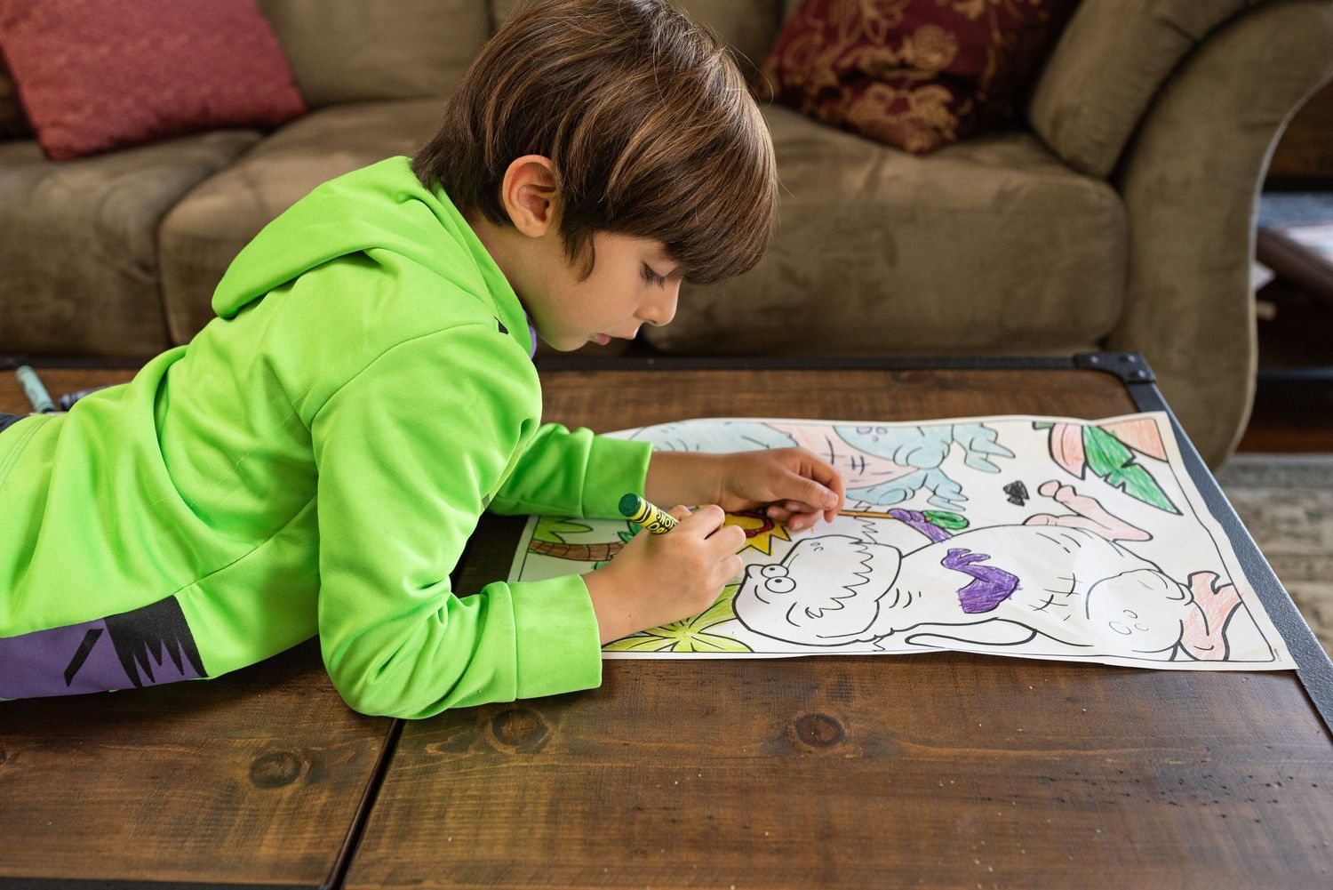 Young boy wearing a neon green shirt that has casts green color on his face. Doughman Photography
