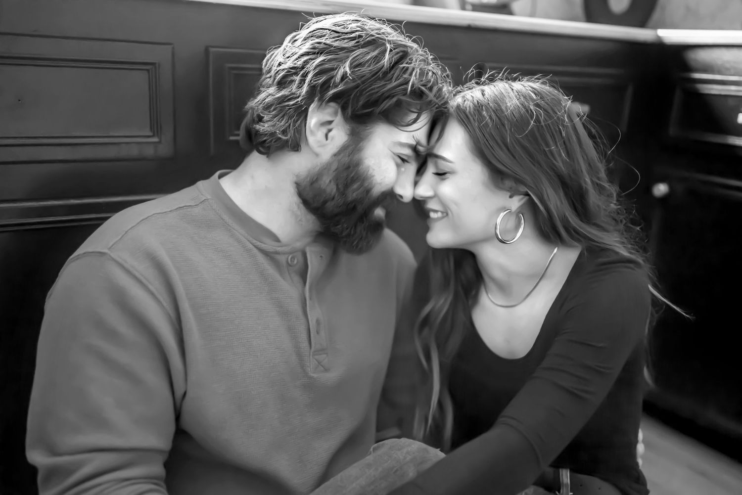 Couple sitting on kitchen floor, leaning against cabinets, foreheads touching. Black & white. Couples in-home session. Doughman Photography