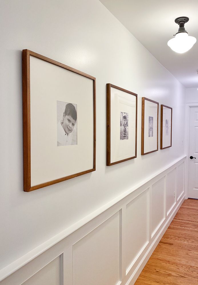 Horizontal gallery wall down hallway of four frames and matted black and white images. Gallery wall design. Doughman Photography.