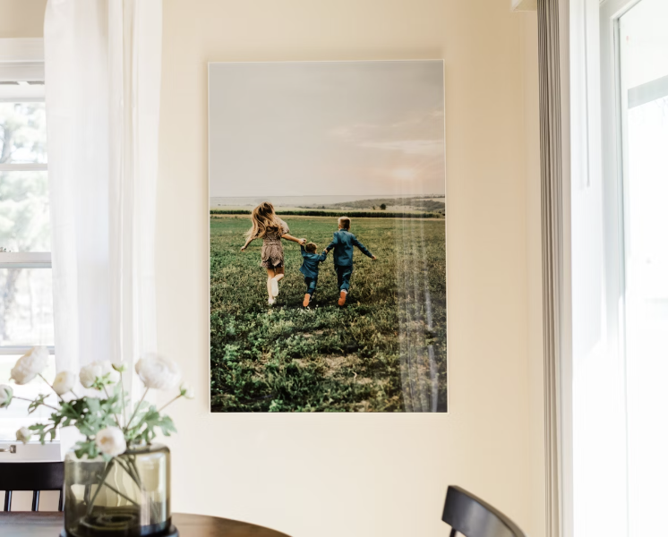 Large acrylic print of family walking in a field. Slight reflection on print from nearby window.