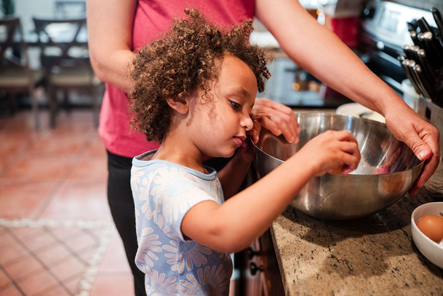 Close up of toddler cracking eggs into bowl. Doughman Photography.