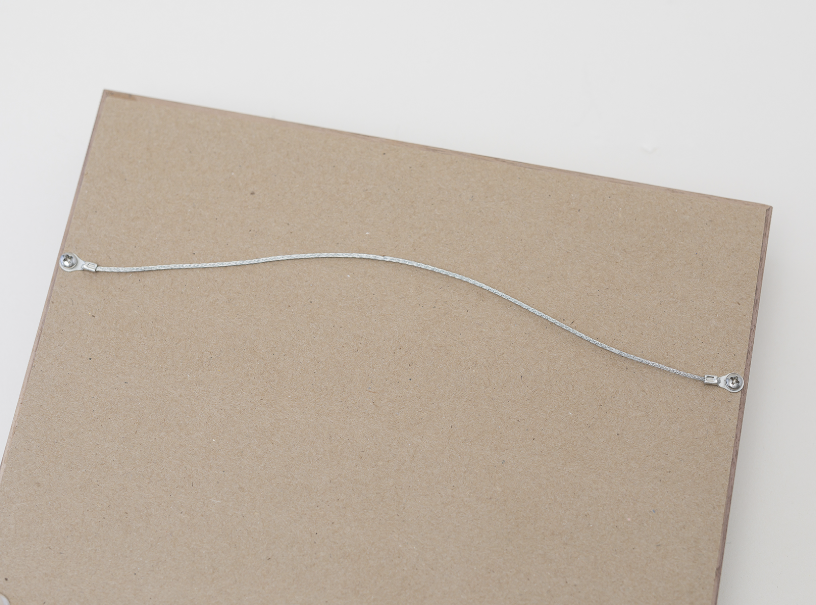 Close up of back of matted framed image to showcase the included wire hanging hardware.