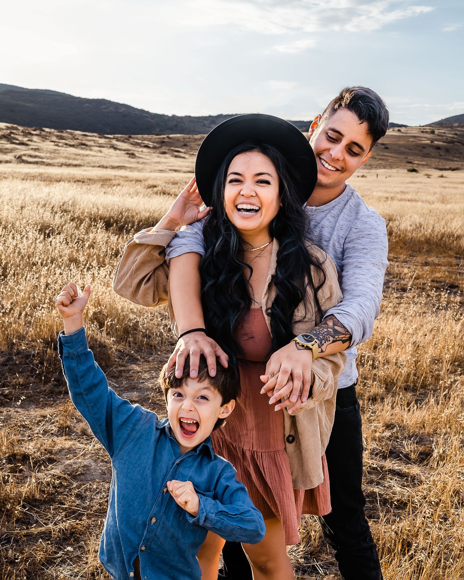 Family in open field wearing dark and emotive color choices. Doughman Photography