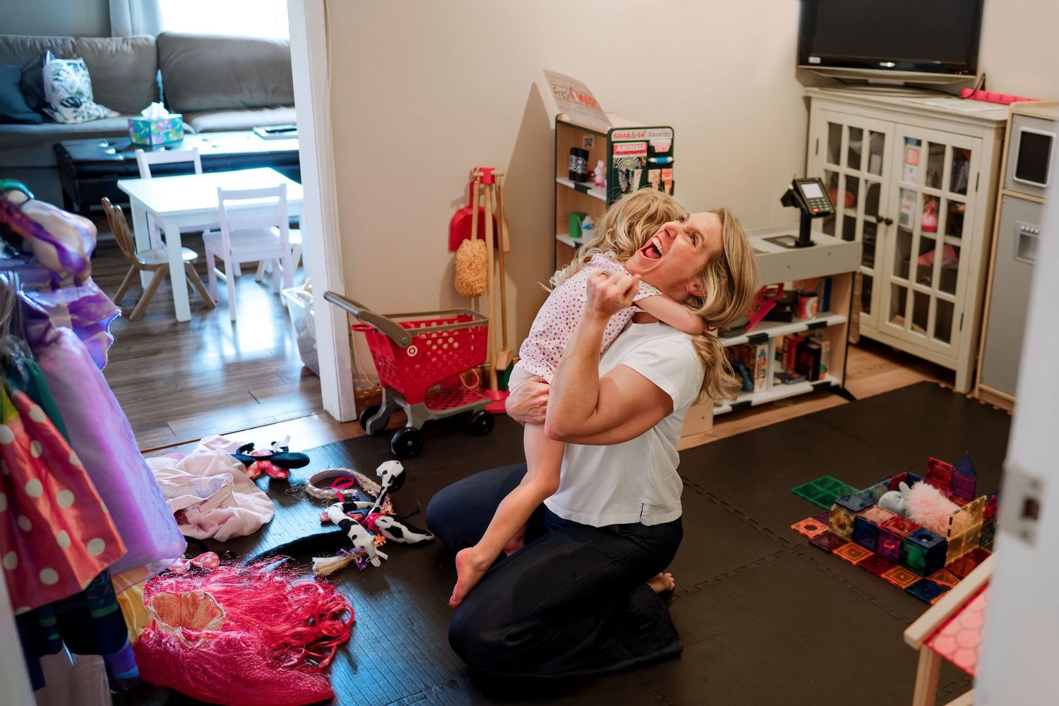 Toddler daughter wrapped in tight hug with mom