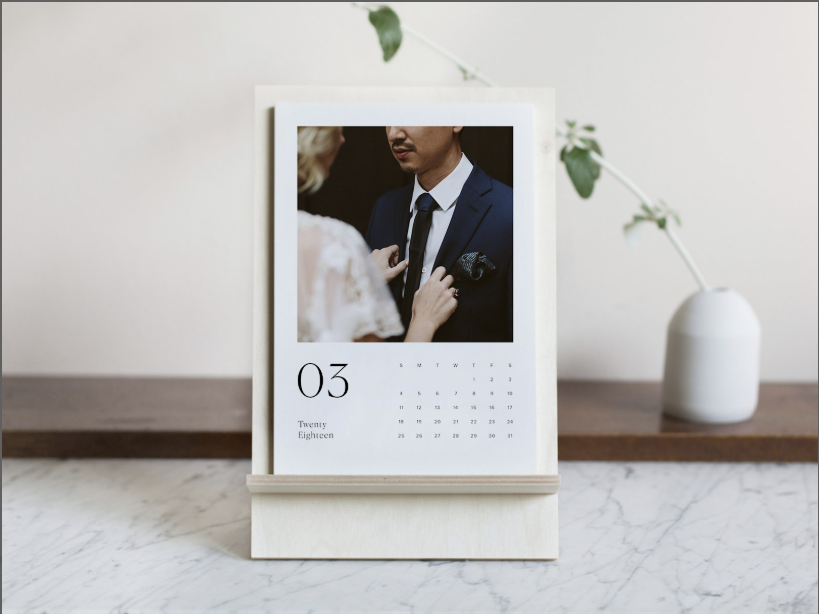 Monthly calendar on wooden stand with a large close up image of a couple. Monthly dates are below the image.