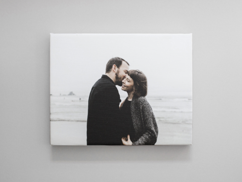 Picture of a canvas print. Canvas print shows a couple at the beach in a loving embrace.