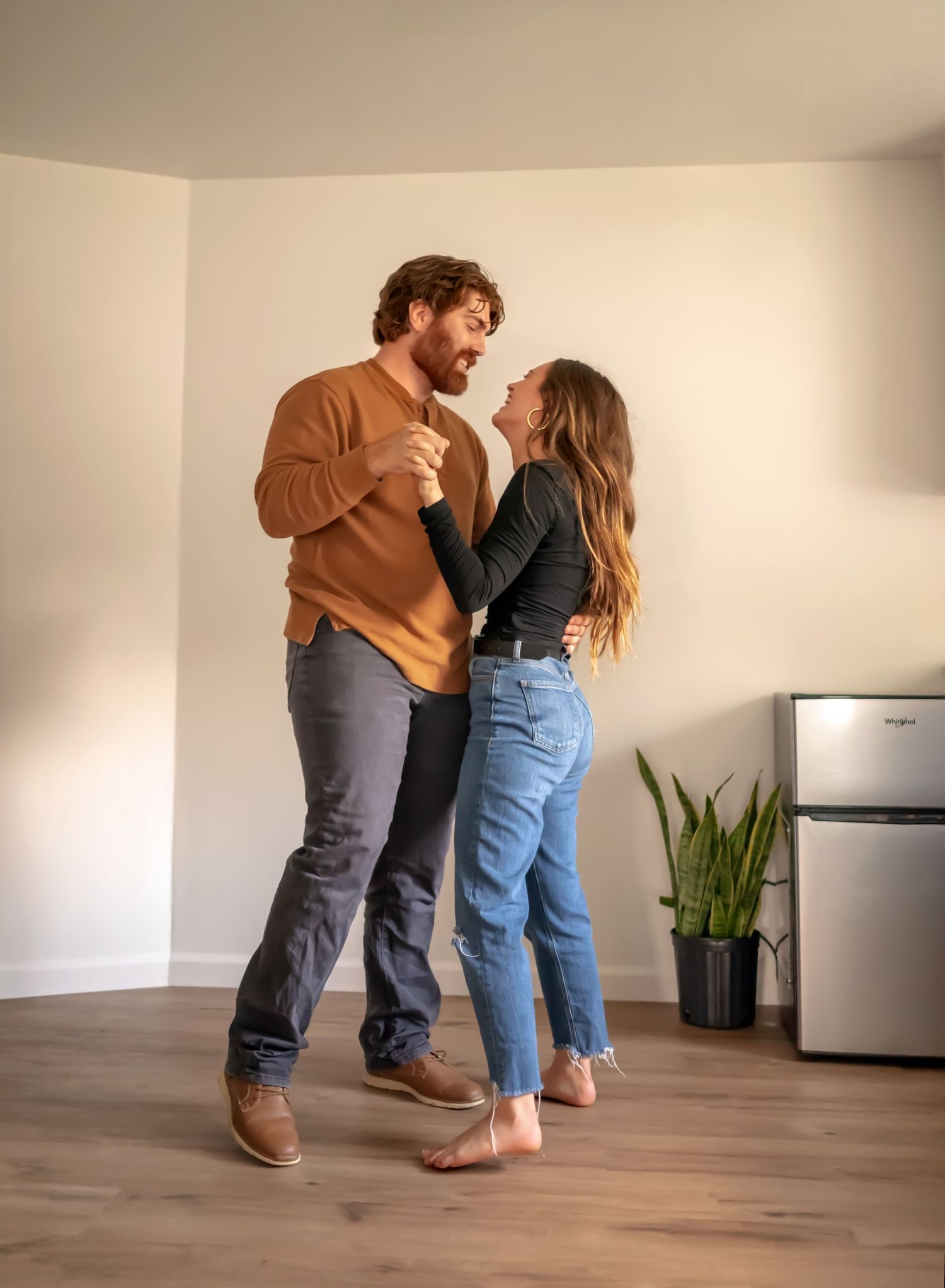 Couple dancing in empty kitchen of their new home. Doughman Photography