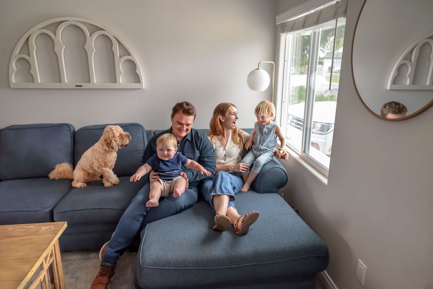 Family gathered together on a couch with their dog