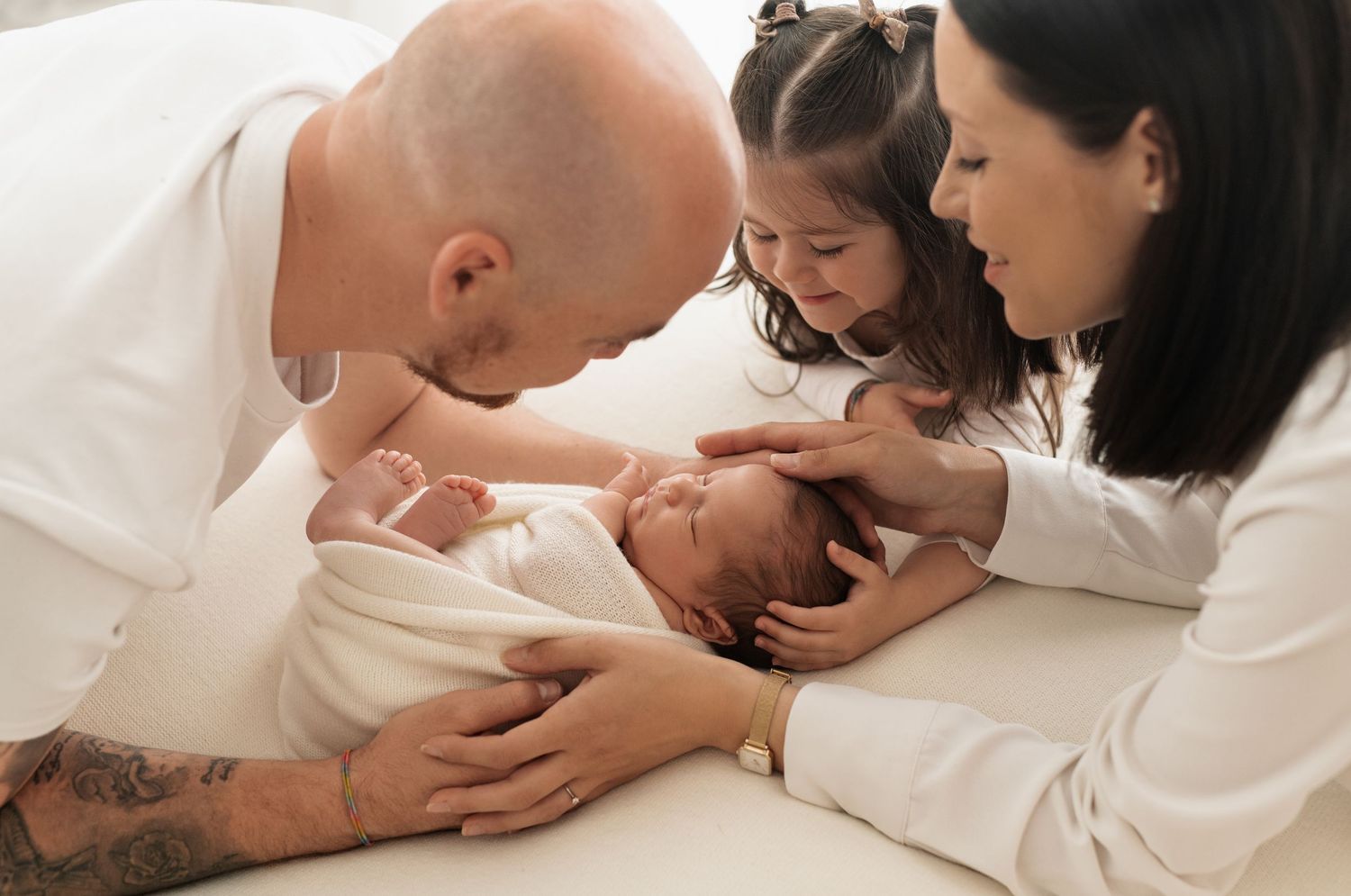 Tender moments between parent and newborn baby shown in a series of intimate black and white photographs.