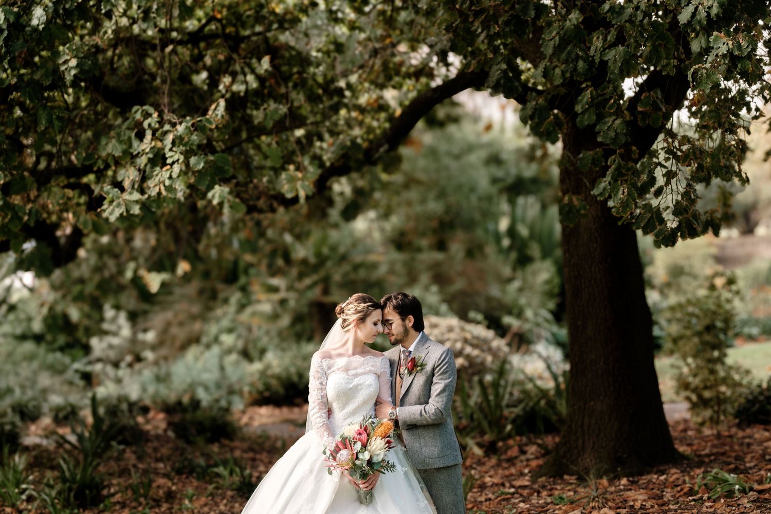Wedding portraits in a lush forest setting with natural greenery and golden light.