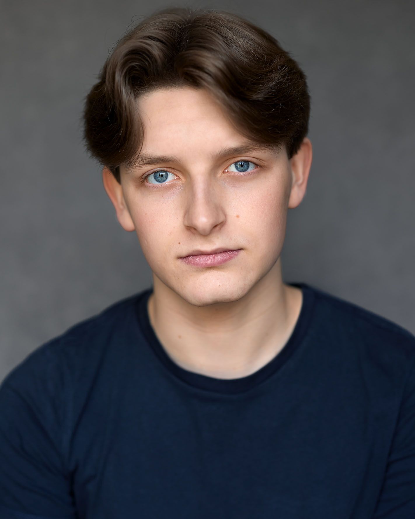 Young man in dark top, dark background:
Actor headshot photographed at Abigail Stewart Photography studio in near Milton Keynes