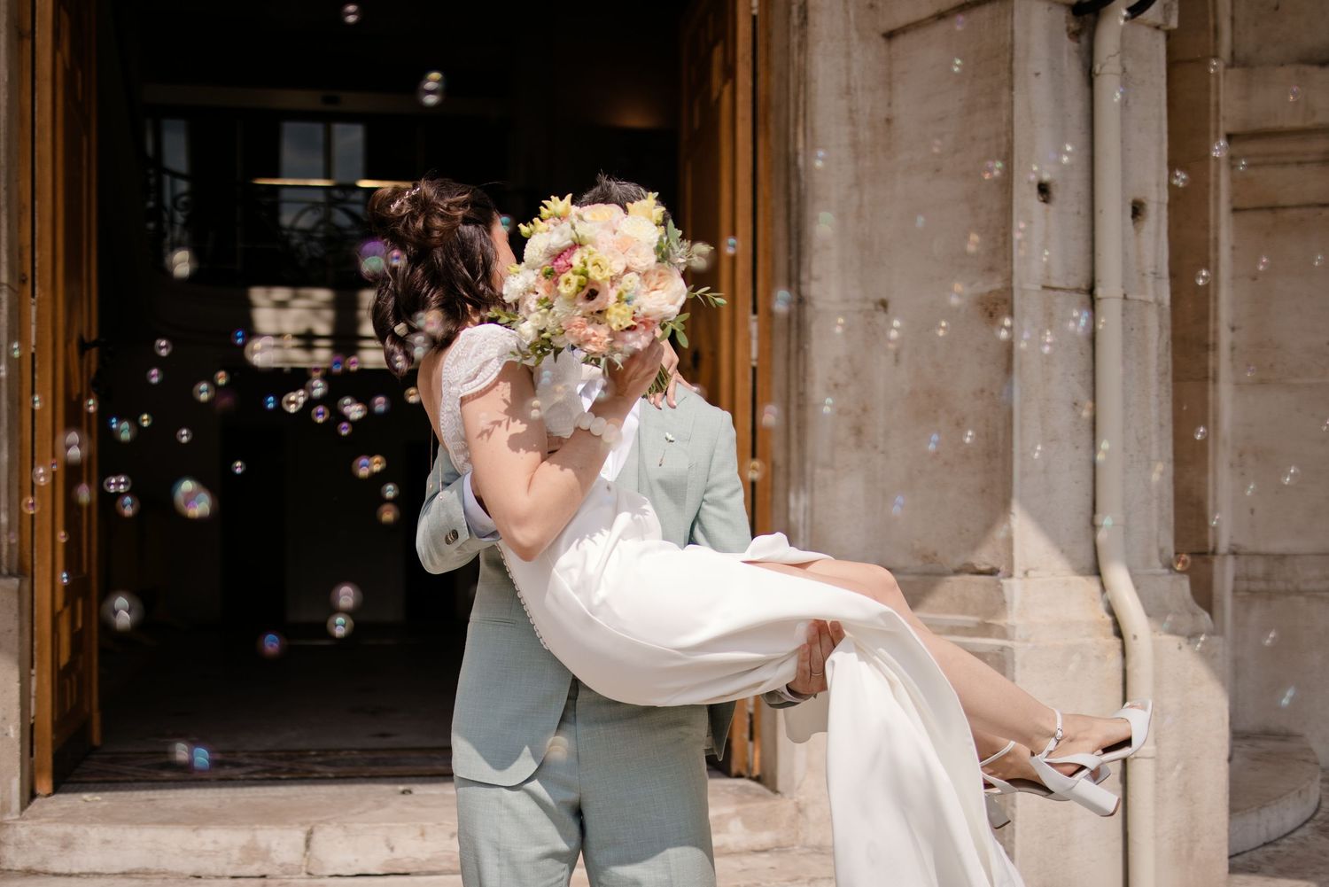 Un couple de mariés s'embrasse à la sortie de la Mairie d'Asnières sur Seine, à l'occasion de leur mariage civil