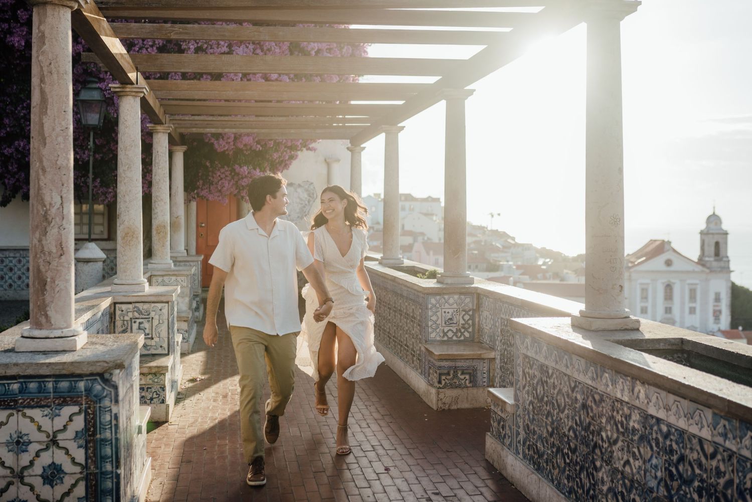 A couple running at Miradouro Santa Luzia in Lisbon. Engagement photoshoot in the early morning.
