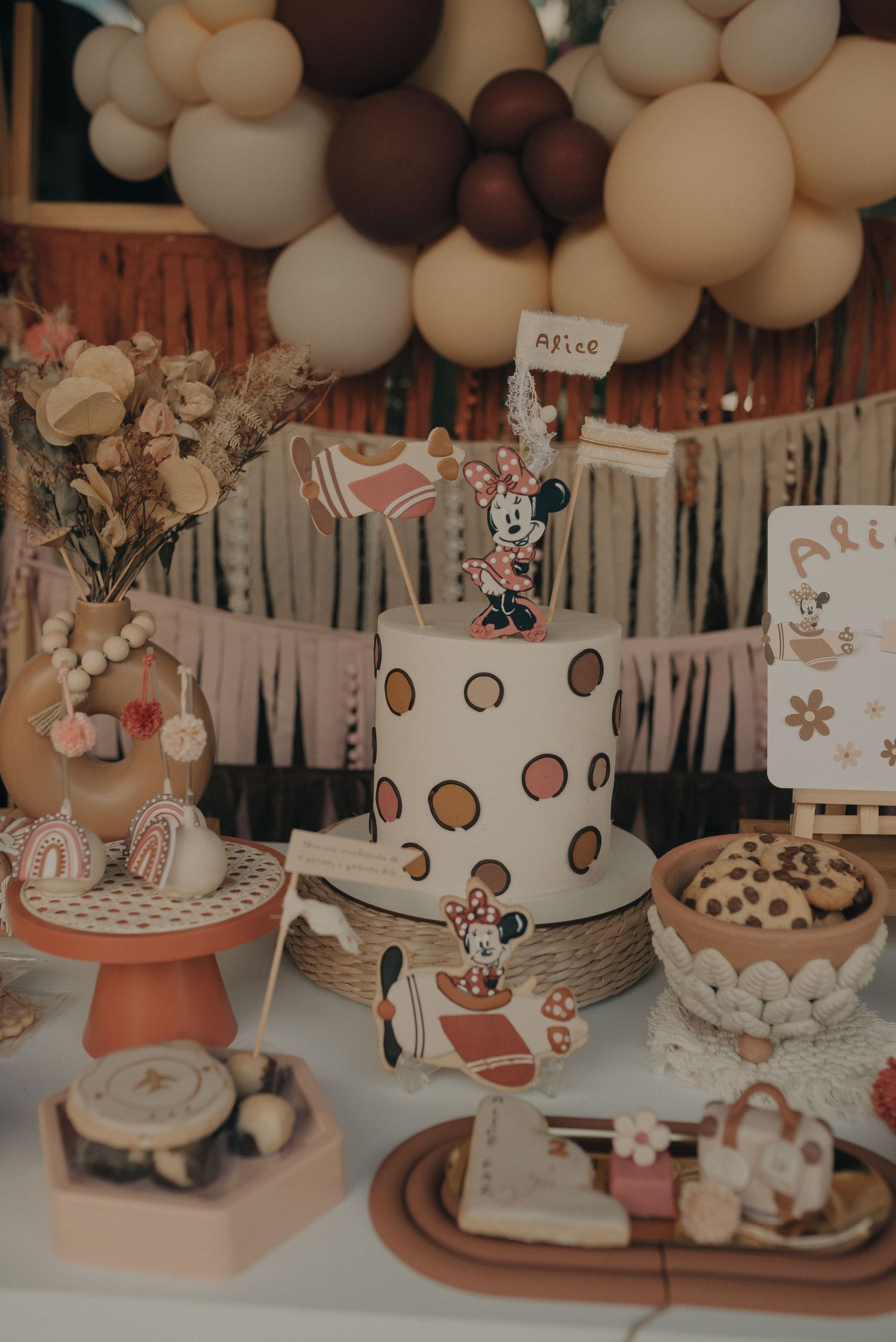 Vintage style dessert table with polka dot cake, balloons, and treats arranged for a celebration.