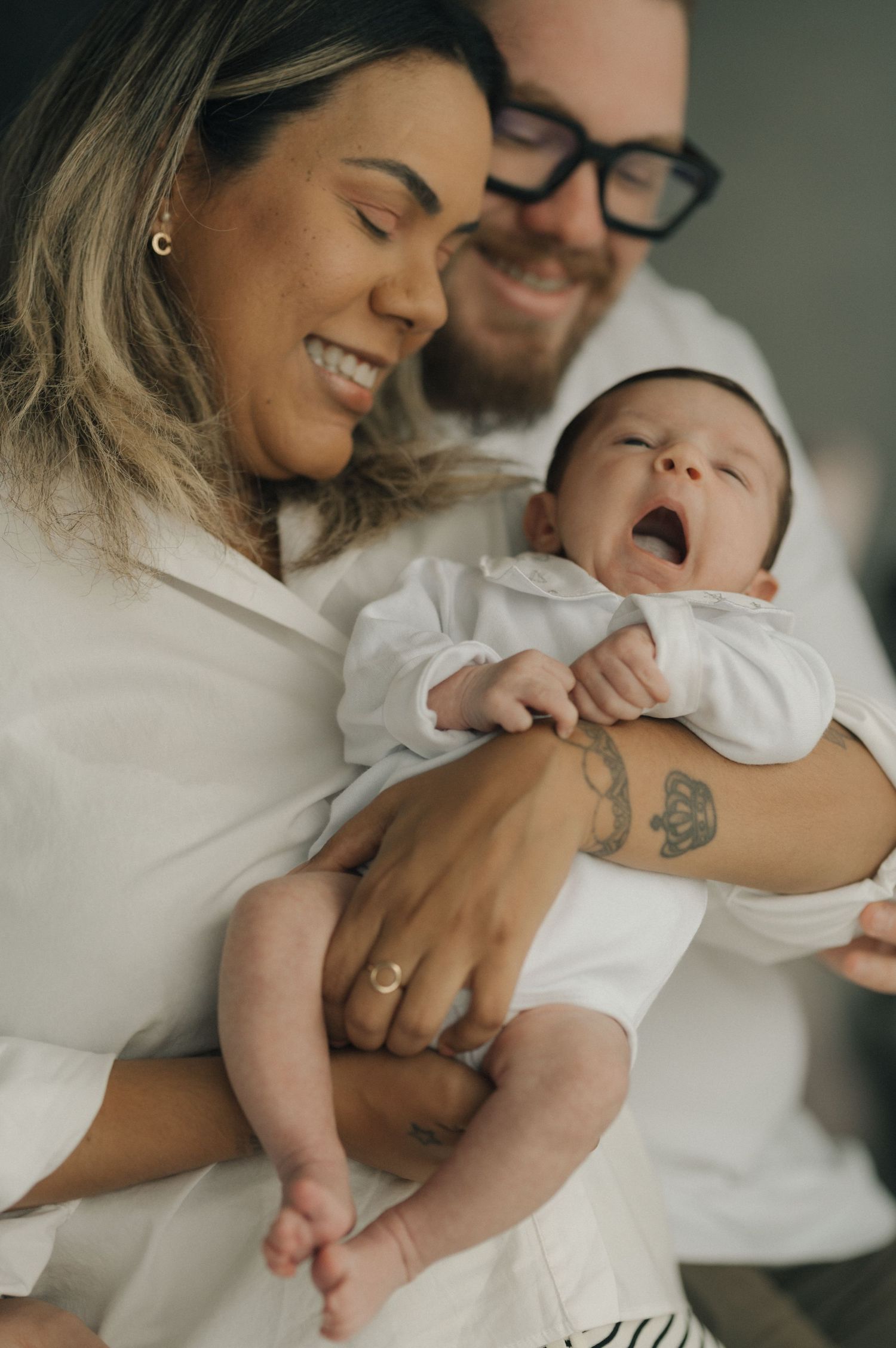 Parents share tender moments with their newborn baby in a series of intimate black and white photographs.