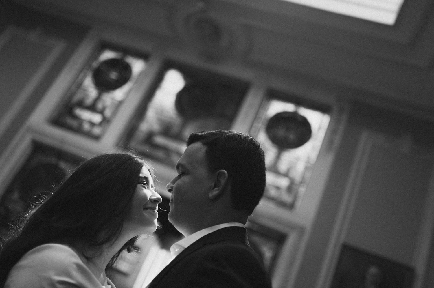 Intimate black and white wedding portrait in an elegant indoor setting.